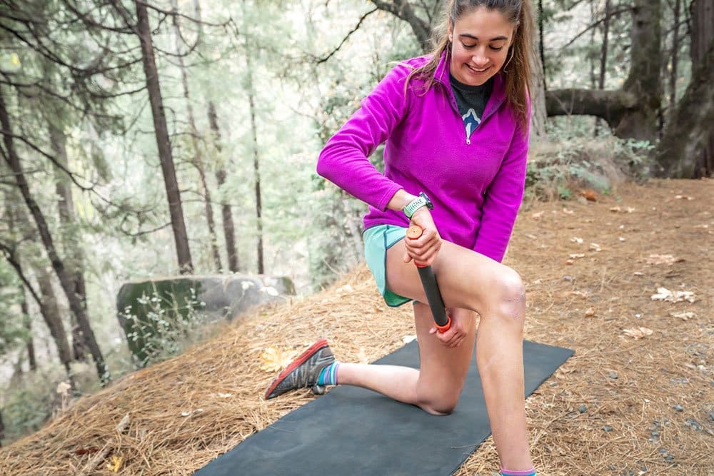 Woman Rolling her IT Band with the Roadster 11" Handheld Foam Roller