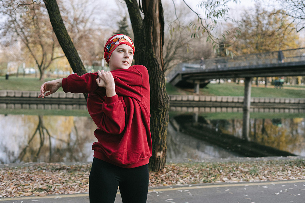 A Woman in Red Sweater Warming Up in the Morning