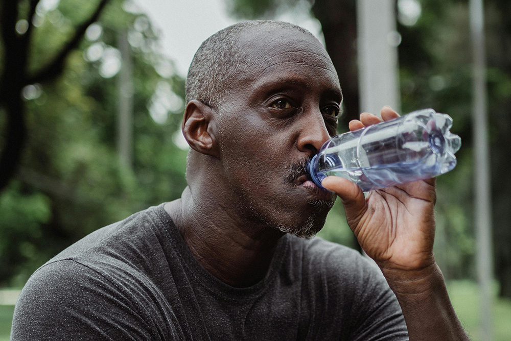 Man drinking water from plastic water bottle