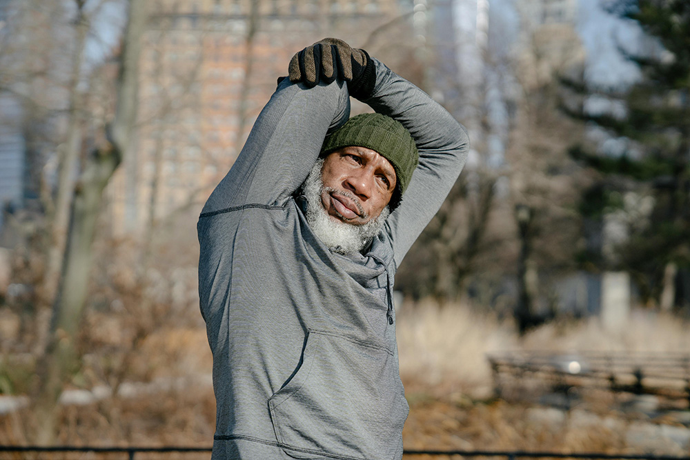 Senior man doing exercise in park in fall