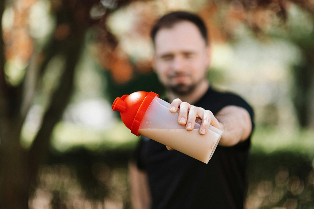 Man holding a tumbler filled with Protein Shake