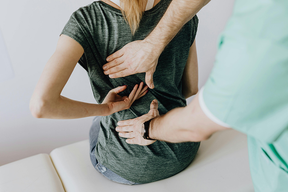 Doctor assessing woman's Back Pain