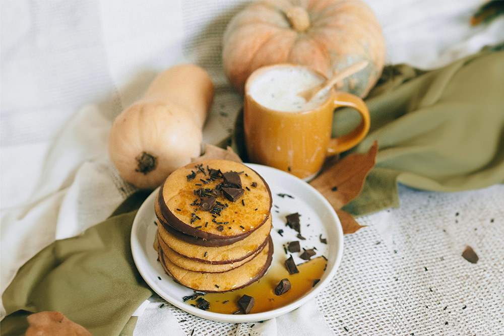 Pumpkin Spice Protein Pancakes on White Ceramic Plate Beside a Cup of Milk