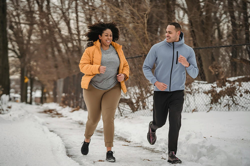 Man and Woman running on a snowy road in winter