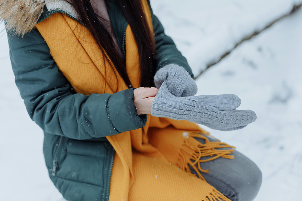 Woman Putting on Winter Gloves