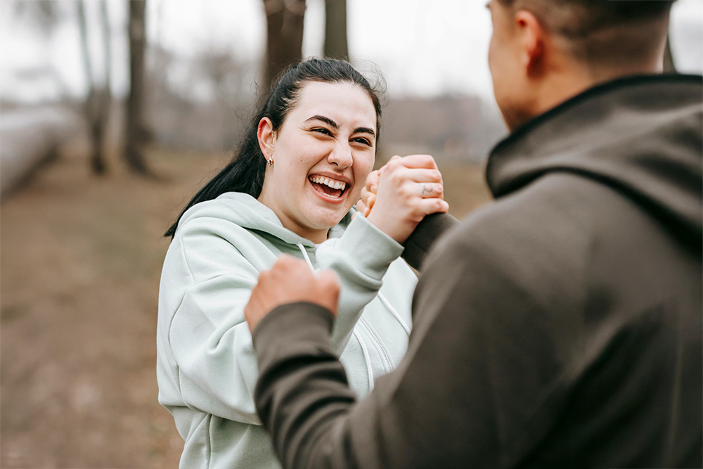 Joyful woman now feeling better shaking hands with trainer