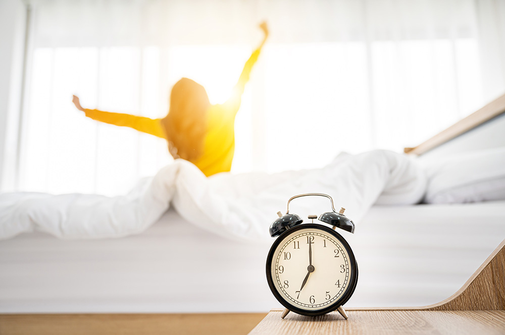 Woman in Yellow Stretching Her Hands Up After Waking Up In The Morning