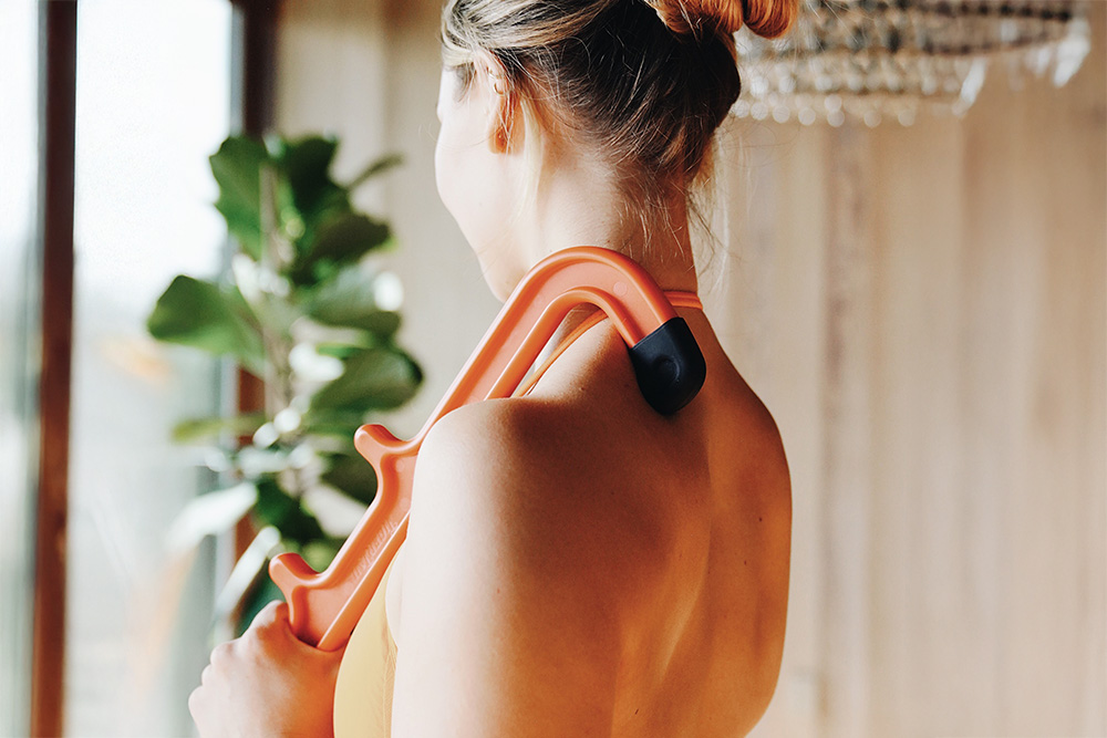 Close-up of muscle recovery therapy being applied to upper arm muscle knots. The image illustrates what is a muscle knot and how shoulder massage knots can be treated using portable massage devices for back and body wellness.