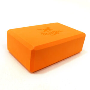 Tiger Tail signature orange yoga block made of supportive, durable foam for stretching and stability.