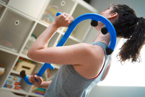 A person uses one of the best myofascial release tools massage hook like the Tiger Cane to massage muscle knots in the back, specifically targeting a painful knot in the shoulder blades for best myofascial release therapy.