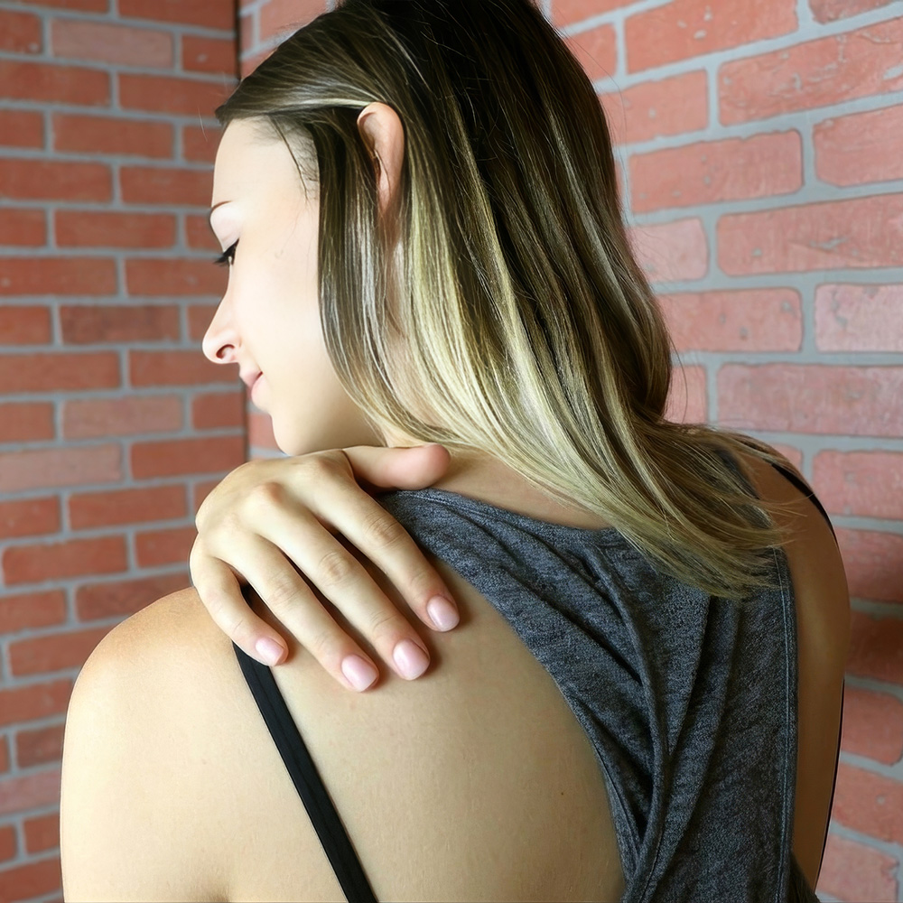 A woman applying Sore Muscle Rub For Back Pain